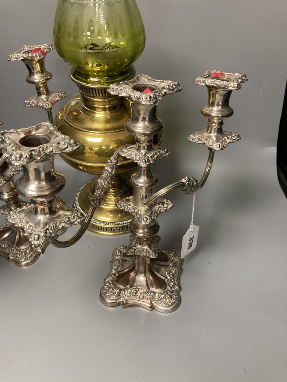 A pair of plated two branch candelabra and a brass oil lamp (3)